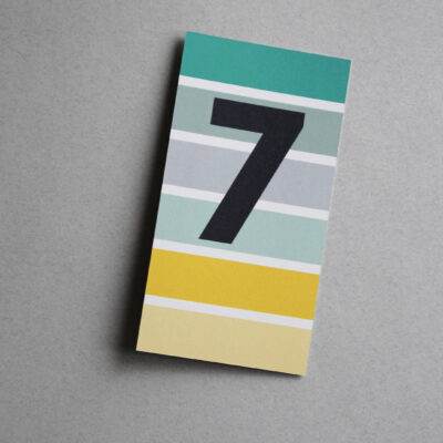 Postkarte bunt gestreift mit der Ziffer 7
