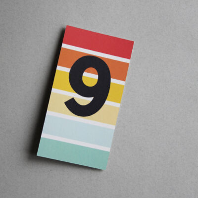 Postkarte bunt gestreift mit der Ziffer 9