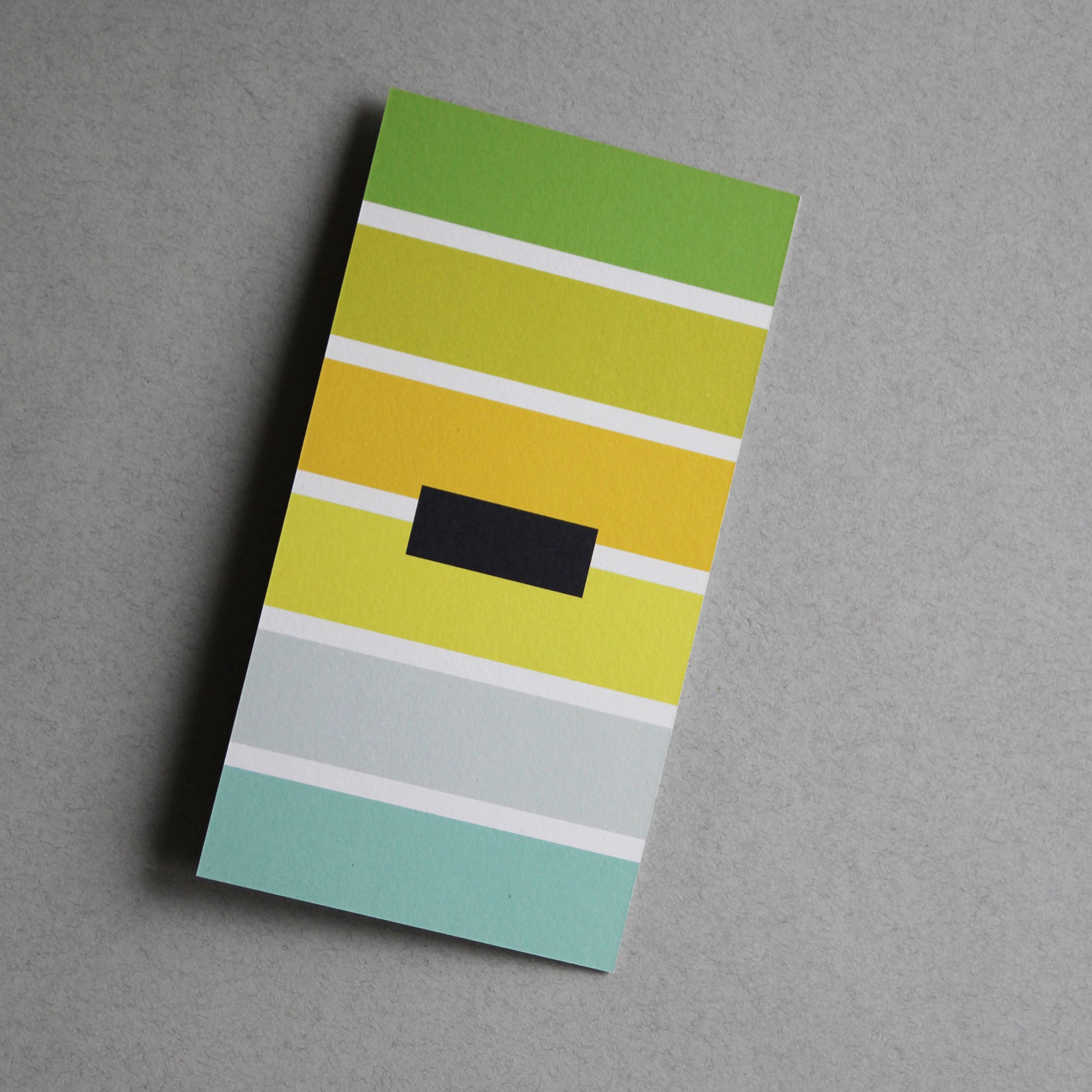 Postkarte bunt gestreift mit dem Sonderzeichen „-“ (minus)